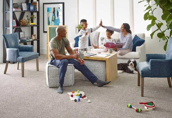 Happy family in living room with carpet floor | Big Bob's Flooring Outlet Yuma